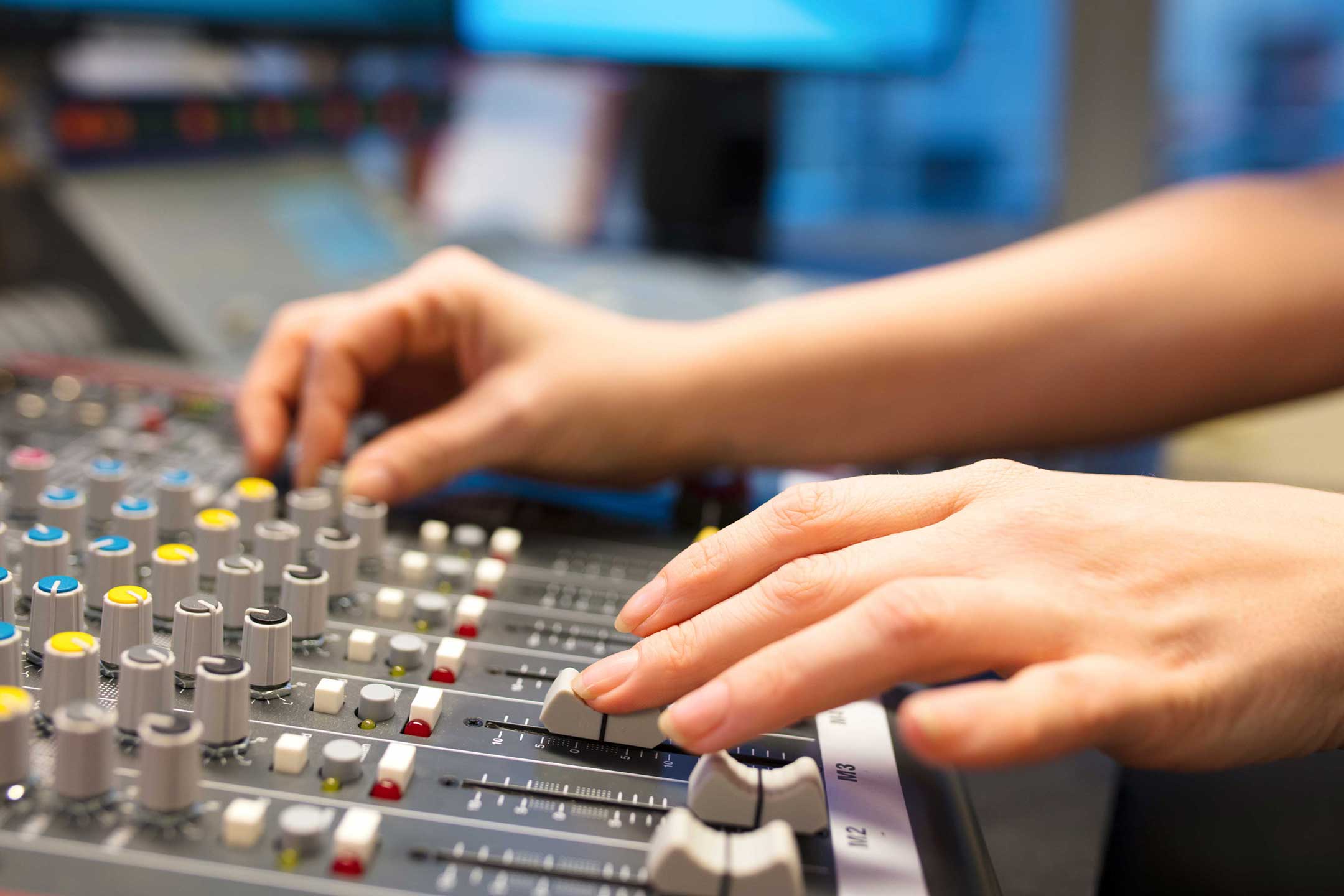 Hands using audio mastering equipment